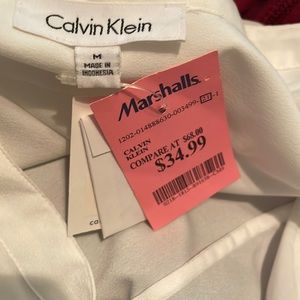 A medium Calvin Klein blouse with gold color buttons and zipper. Never worn.